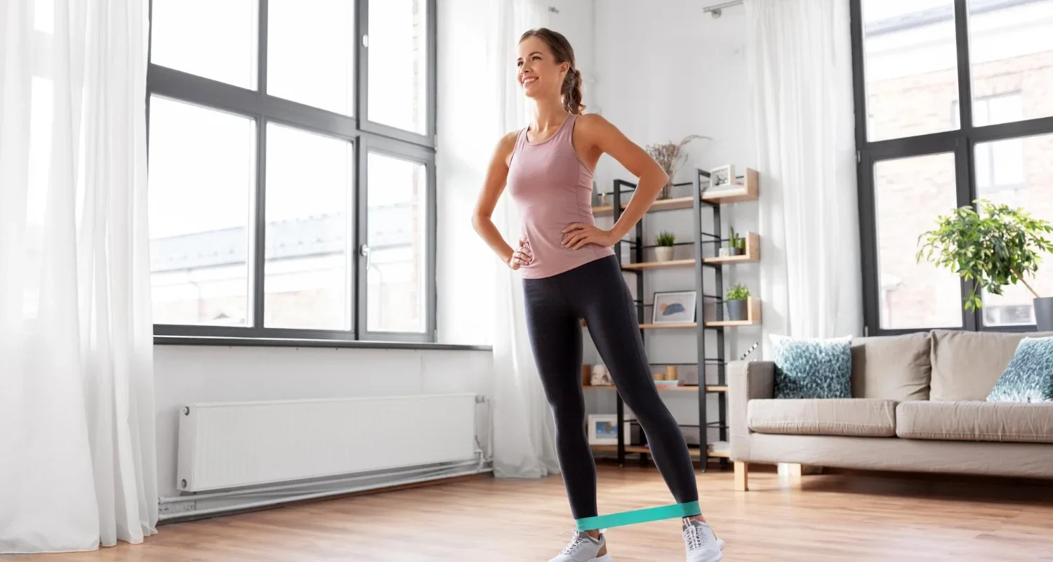 Woman over 40 doing modified strength training with resistance band at home