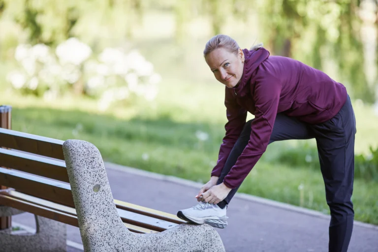 Woman lacing up sneakers preparing to start her fitness journey