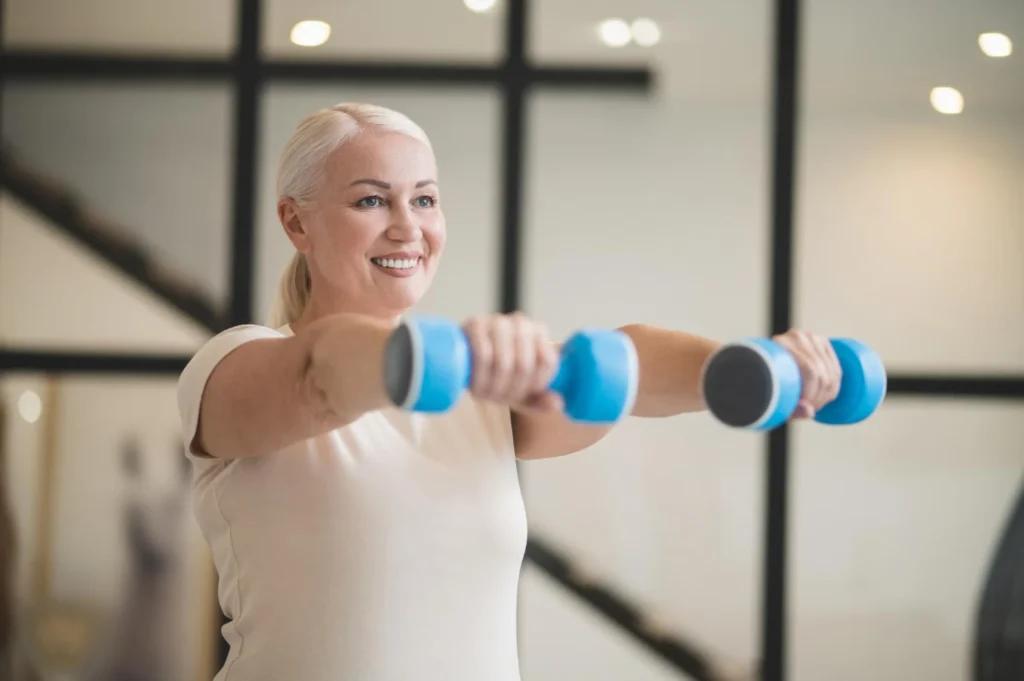 Woman over 40 strength training with dumbbells at home