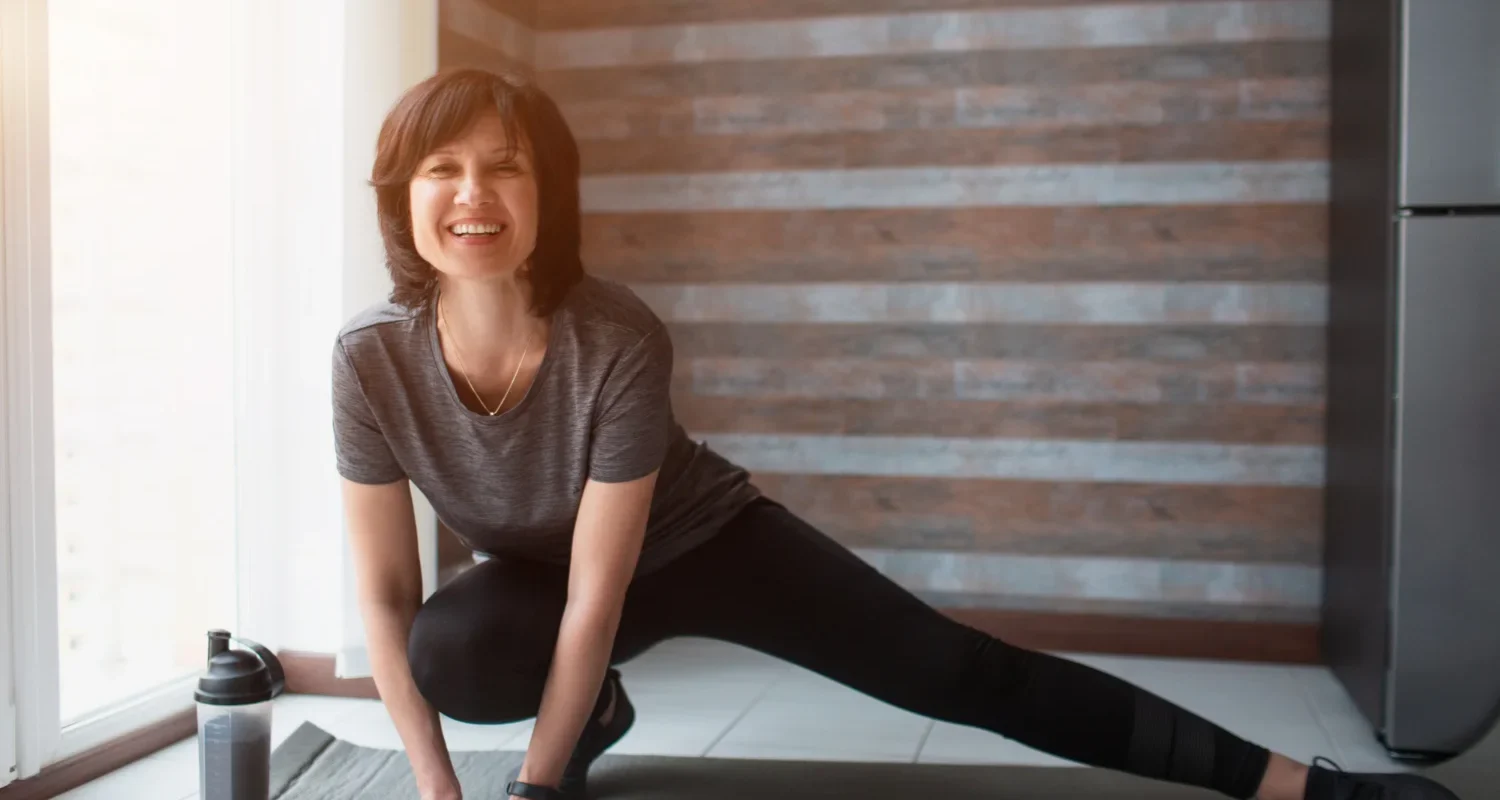 Fit mature woman exercising with dumbbells at home