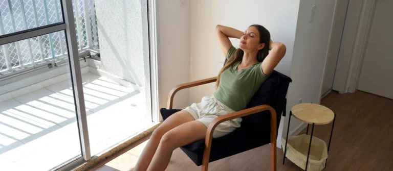 Woman relaxing in a chair with warm soft lighting in a calm restful room