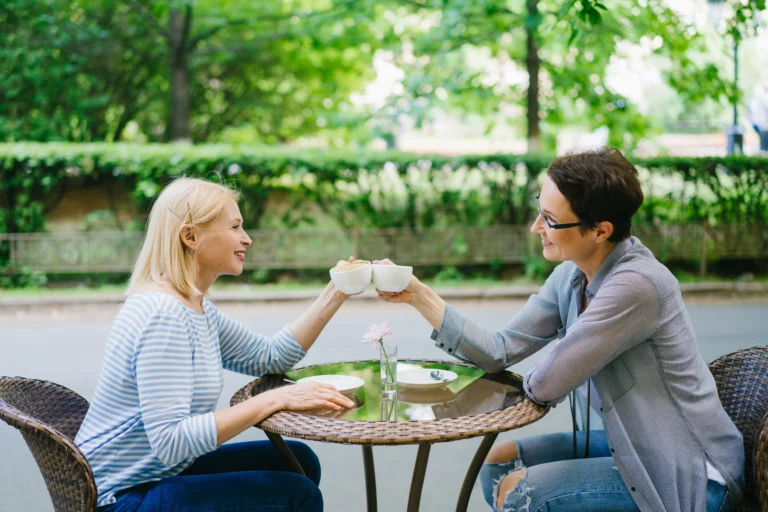 Two women talking over tea at an outdoor café