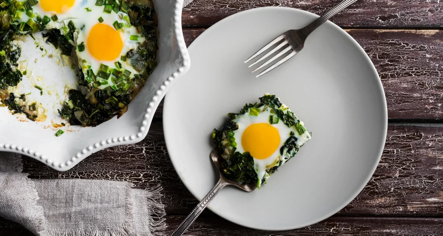 Spinach and feta scramble served on a white plate with fresh spinach