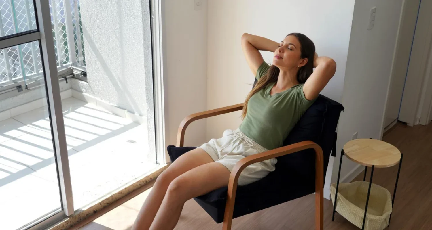 Woman relaxing in a chair with warm soft lighting in a calm restful room